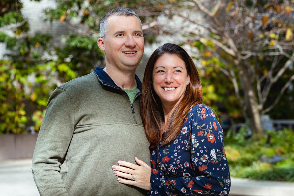 Michael and Megan Serke smiling together outside in front of some trees